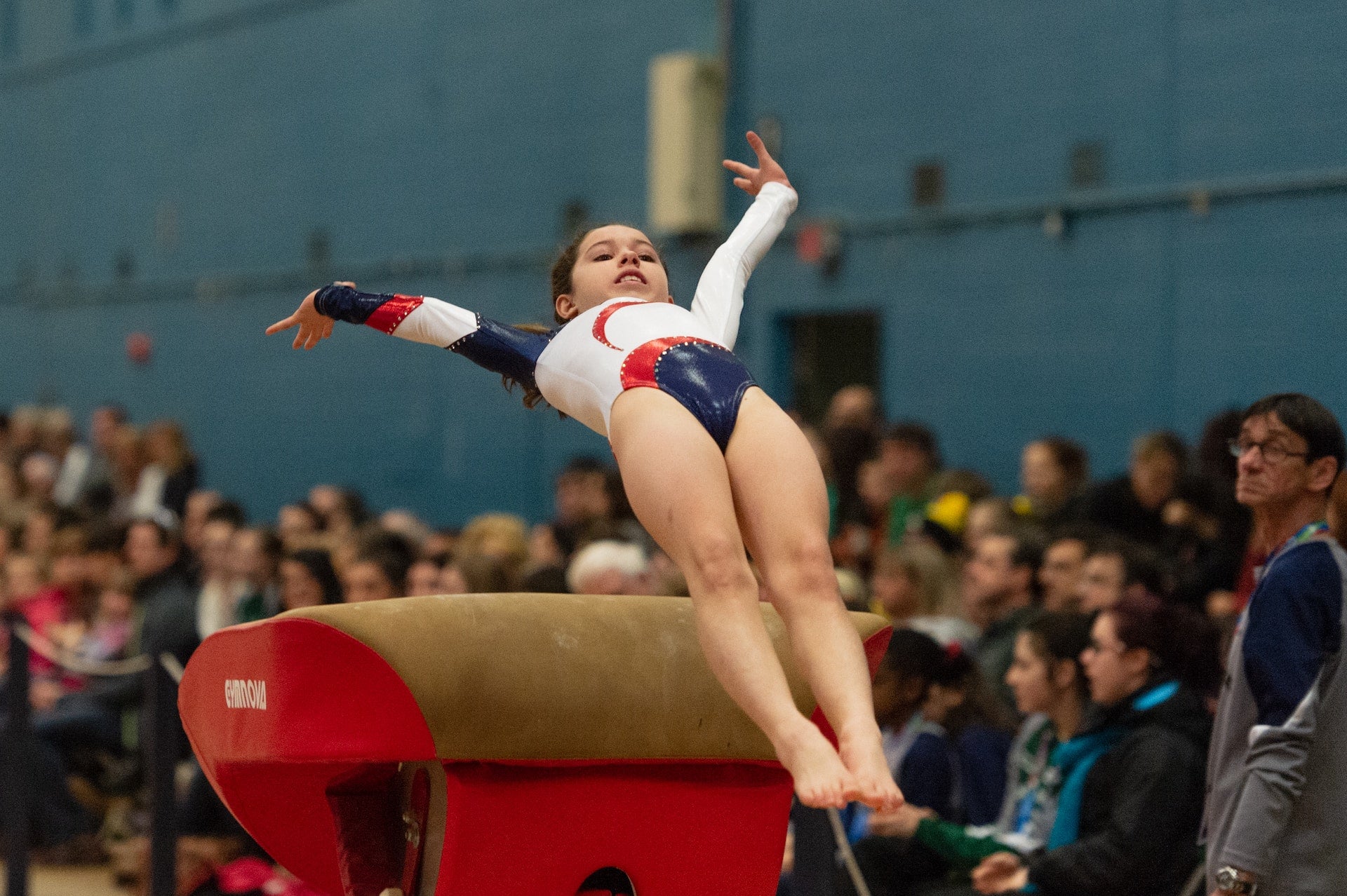 Young woman doing gymnastics, wearing a gym leotard and tights